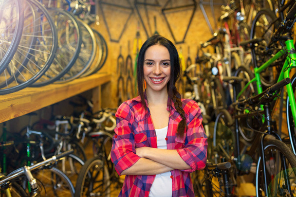 Bir bisiklet tamir dükkanında çalışan genç kadın - Fotoğraf, Görsel