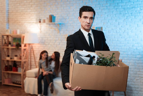 Frustrated businessman holding box with things and leaving his family - Foto, Imagem