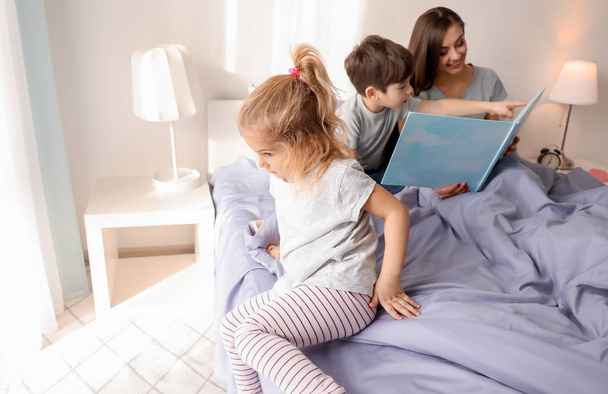 Mother reading bedtime story to children at home - Φωτογραφία, εικόνα
