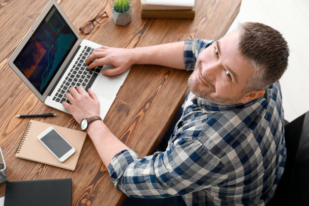 Handsome man working with laptop indoors - Foto, Imagem