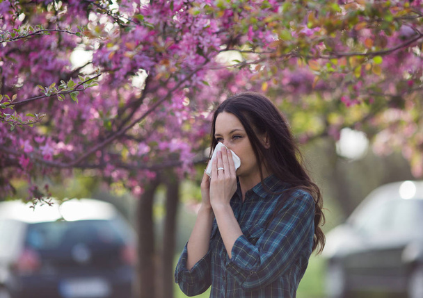 Femme qui se mouche à cause d'une allergie au pollen printanier
 - Photo, image