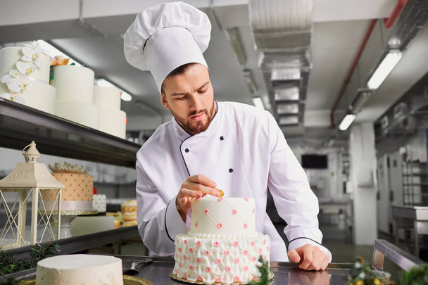 Confectioner with a cake in the bakery.  - Foto, afbeelding