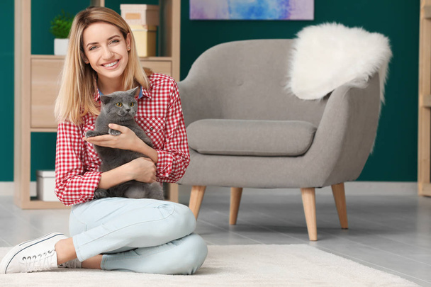 Young woman with cute pet cat at home - Foto, afbeelding