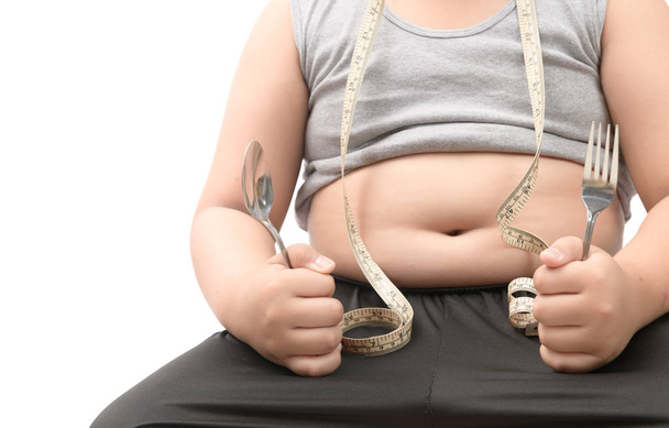 Obèse gros garçon tenant fourchette et cuillère
 - Photo, image