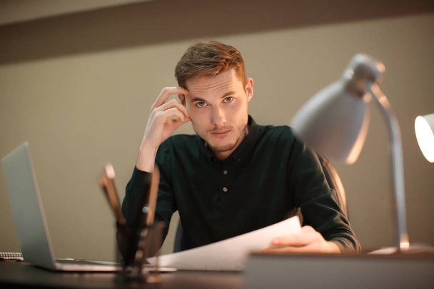 Young handsome man working in office - Foto, afbeelding