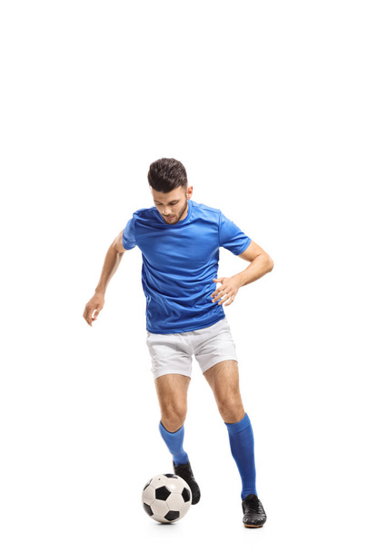 Full length portrait of a soccer player dribbling isolated on white background - Foto, imagen