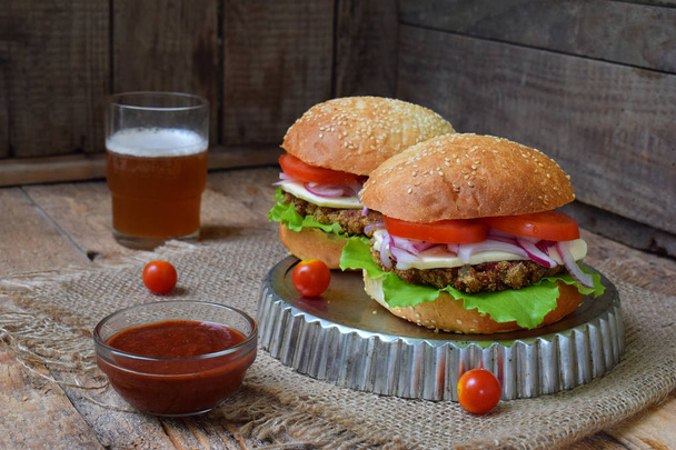 Vegetariánské burgery s chop lilek, hlávkový salát, nakládaná cibule, rajče na hnědé dřevěné pozadí. Vegetariánské obědy nebo večeře nápad. Zdravé jídlo. - Fotografie, Obrázek