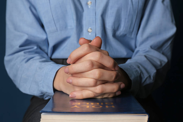 Religious young woman praying over Bible, closeup - Photo, Image
