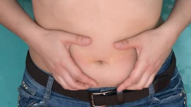 女の子は、彼女の胃の脂肪を示しています。 - 映像、動画
