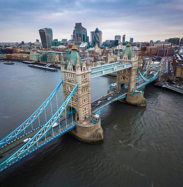 London, Anglia - légi panormaic kilátás nyílik a legendás Tower Bridge és a Tower of London egy felhős fakuló felhőkarcoló a pénzügyi Bank negyed háttér - Fotó, kép