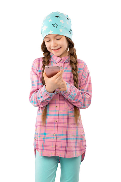 Una niña dulce jugando juegos en su teléfono móvil aislado sobre fondo blanco
 - Foto, Imagen