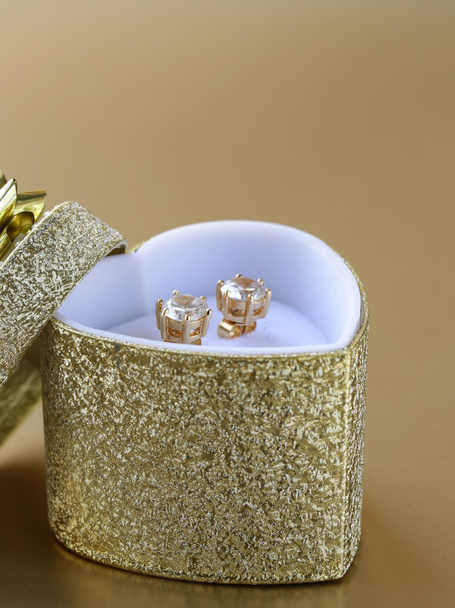 Orecchini in oro stallone con diamanti in una scatola d'oro
 - Foto, immagini