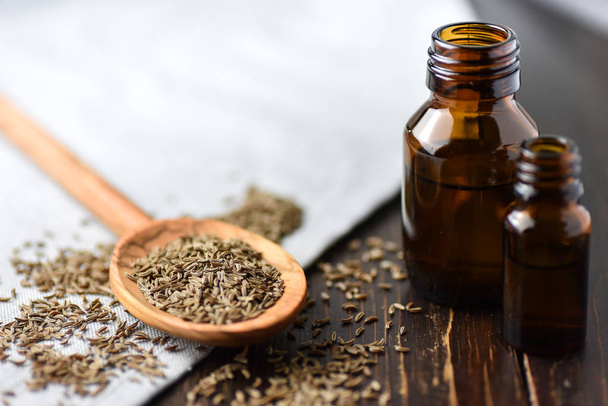 caraway oil and seeds on wooden spoon and essential oil - Photo, Image