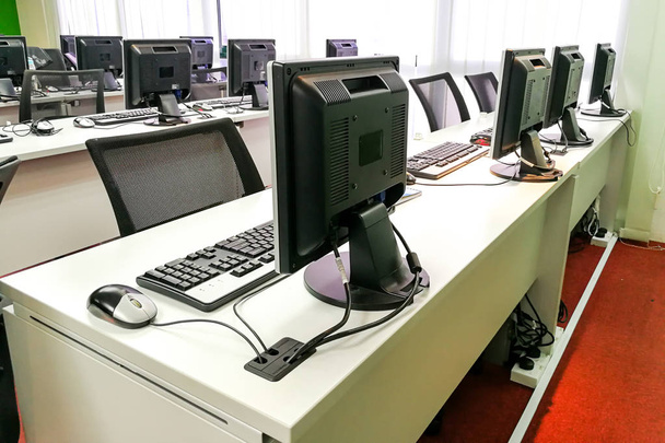 Sala de aula de computador vazia com monitores em cima da mesa
 - Foto, Imagem