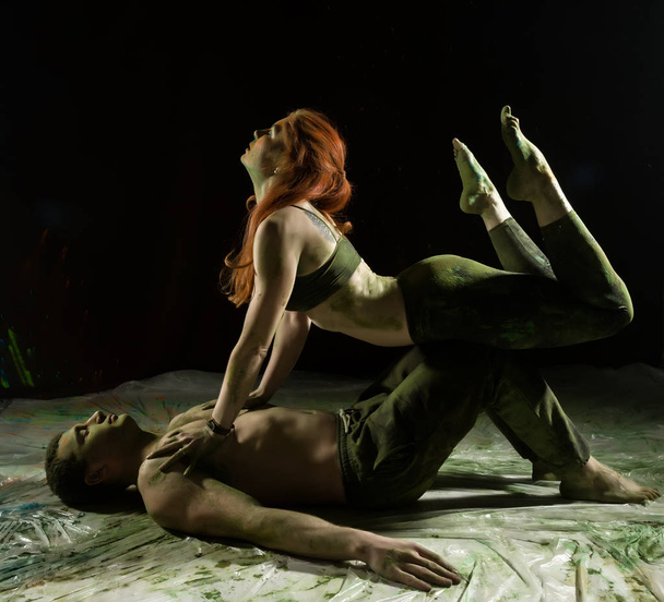 sports man and woman doing acroyoga exercises in a dark room with colorful smoke - Foto, Imagem