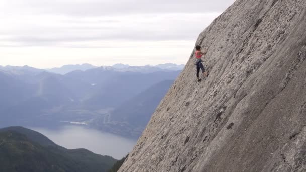 Drone aéreo de caucásico americano trepador mujer escalada usando la cuerda para subir la pared rocosa extrema en Canadá Valle de Squamish - Metraje, vídeo