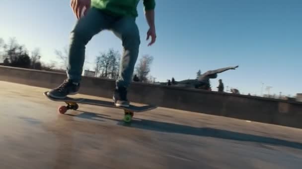 Skateboardista dělá triky, skákání na rampu venku - Záběry, video