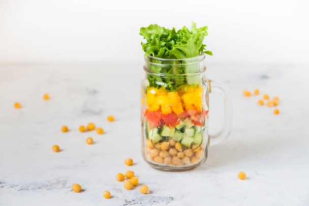 Salat im Glas. hausgemachter gesunder Salat aus Kichererbsen, Tomaten, - Foto, Bild