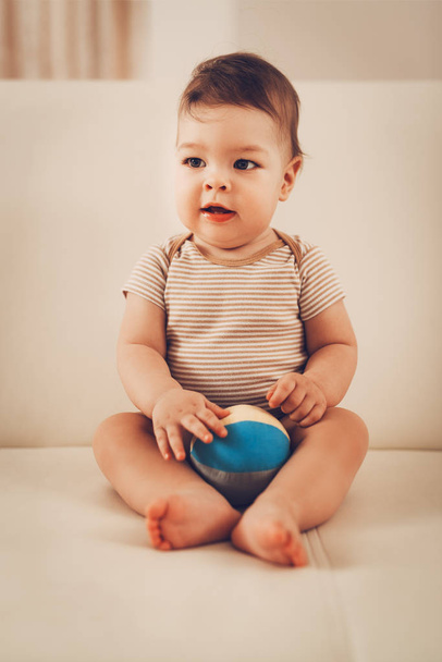 Playful baby boy sitting on bed with toys at home - Φωτογραφία, εικόνα
