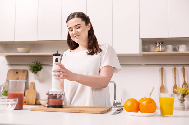 Pleased appealing woman making smoothie - Photo, image