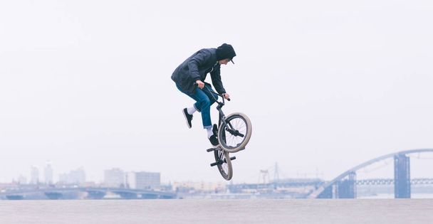 BMX rider makes a TAilwhip trick. Young man doing tricks in the air on a BMX bike. BMX freestyle - Photo, Image