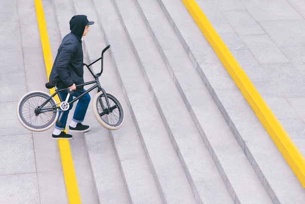 Walk around the city with BMX by bike. BMX concept. The man goes upstairs. Top view. Copyspace. - Фото, изображение
