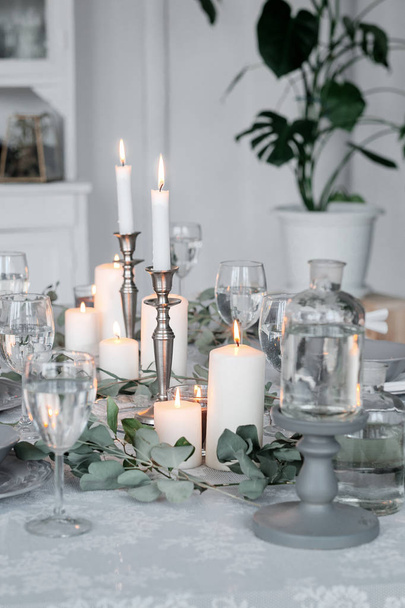 Wedding or festive table setting. Plates, wine glasses, candles and cutlery - Φωτογραφία, εικόνα