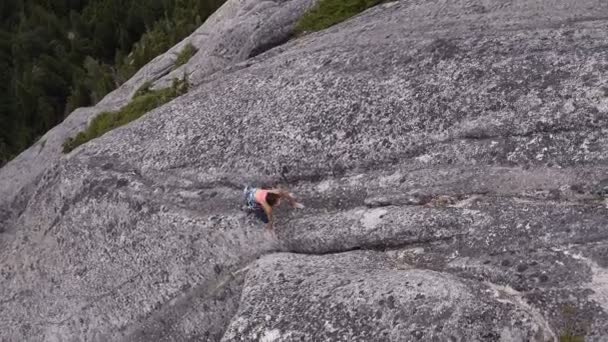 Aerial drone view of Caucasian American female adventure climber belaying mountain rock Mt Habrich in Squamish Valley Canada - Footage, Video
