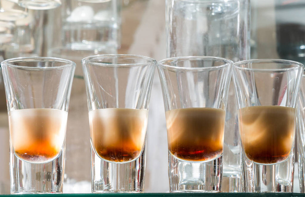 Услуги общественного питания. Празднование. стаканы со спиртом, помещенные на стекло
 - Фото, изображение
