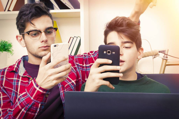 studenten met de computer en mobiele telefoon thuis - Foto, afbeelding