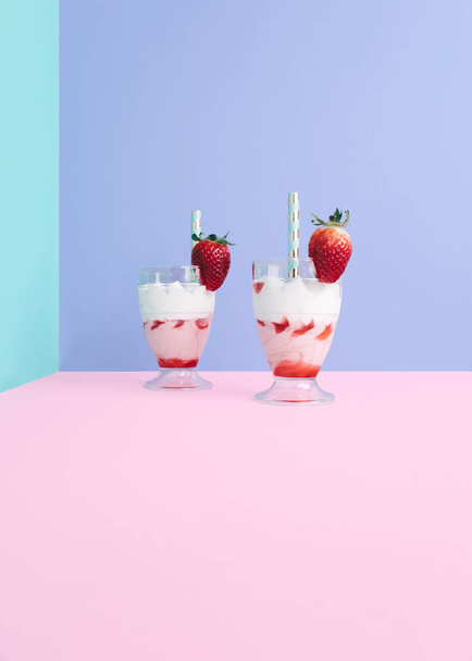 Milkshake with straw and strawberry. - Foto, afbeelding