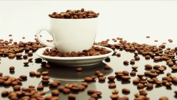 κόκκους καφέ που ξεχειλίζει από άσπρα καφέ - Πλάνα, βίντεο