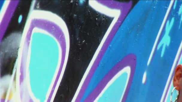 Pan a través de modelo de moda en la pared de graffiti con gafas de sol
 - Metraje, vídeo