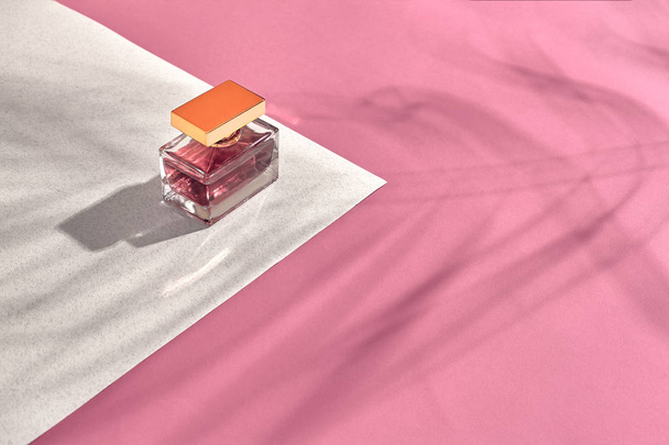 Cosméticos y accesorios de moda para mujer. Lay plana. Perfume. Fondo rosa y blanco. Sombra de una hoja de palma
 - Foto, imagen