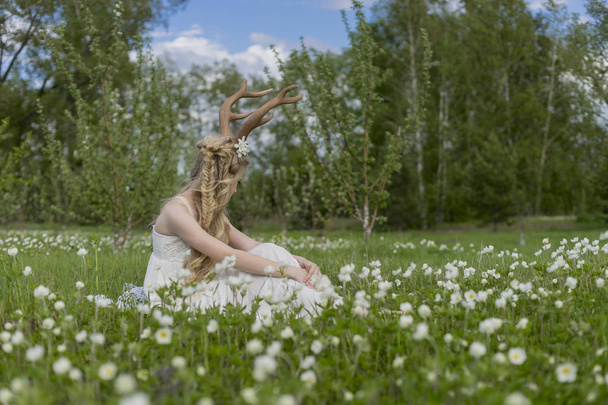 Teen beautiful blonde girl wearing white dress with deer horns o - Photo, Image