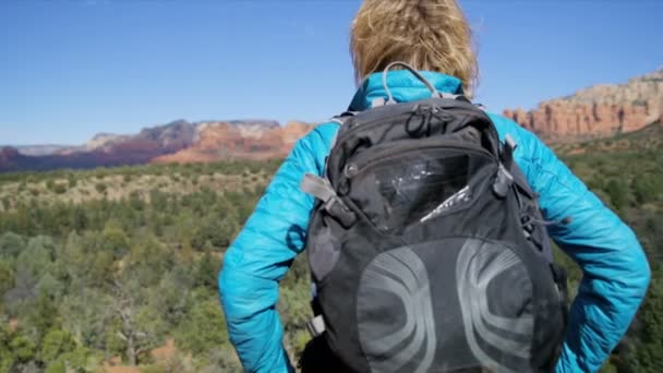 Mujer americana caucásica activa logrando sus ambiciones trekking arenisca roja Verde Valley Arizona USA
 - Imágenes, Vídeo
