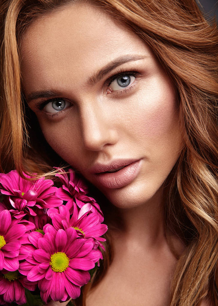 Piękno portret moda model młody blond kobieta z naturalnego makijażu i perfect skin z jasnym szkarłatny kwiat pozowanie Studio - Zdjęcie, obraz