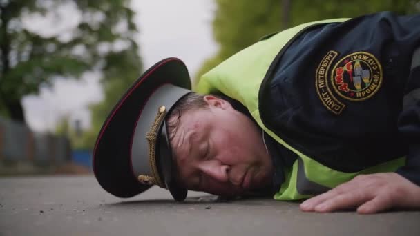 Αξιωματικός υπηρεσίας τροχαίας χτυπημένο και κουρασμένος που πέφτει στον δρόμο - Πλάνα, βίντεο