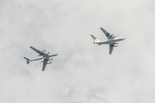 δύο Il-78 και Tu-95 αεροσκάφη ανεφοδιασμού στον αέρα, που φέρουν κατά το συννεφιασμένο ουρανό - Φωτογραφία, εικόνα