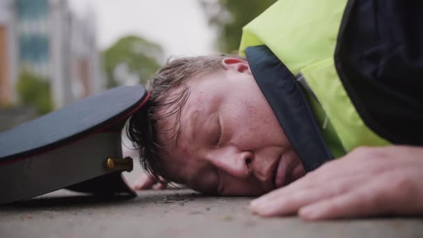 Policial de trânsito espancado e cansado deitado na estrada e grita com medo
 - Filmagem, Vídeo