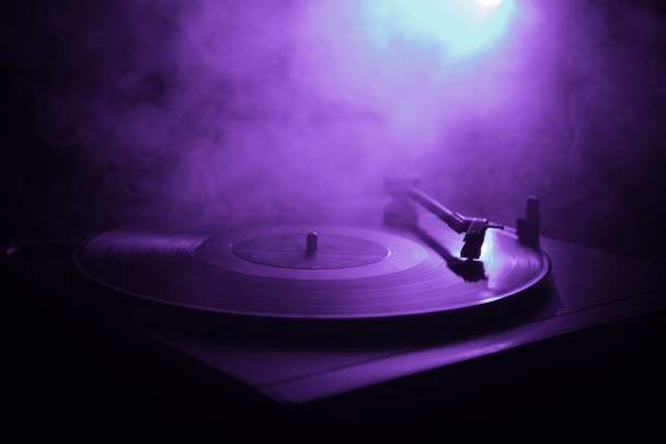 ターン テーブル ビニール レコード プレーヤー。ディスク ジョッキーのレトロなオーディオ機器。Dj ミックス ・音楽を再生するためのサウンド テクノロジー。燃焼火災の背景に対して再生されてビニール レコード - 写真・画像