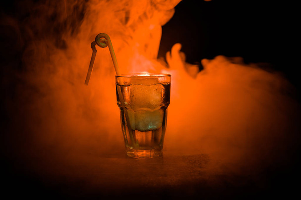 Alkol kokteyl bardağına buz koyu arka plan üzerinde duman ile. Club içecekler kavramı. Kokteyl bir bardak. Seçici odak - Fotoğraf, Görsel