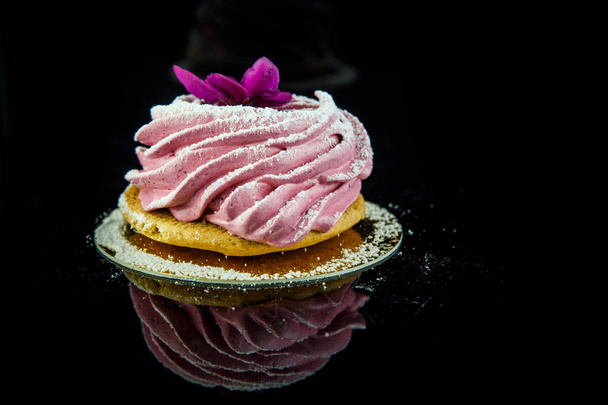 biscuit zéphyr fait à la main décoré de fleurs violettes sur fond miroir noir avec réflexion
 - Photo, image