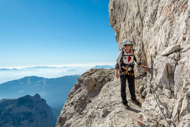 Ευτυχισμένη γυναίκα ορειβάτης αναρρίχηση μέσω ferrata. - Φωτογραφία, εικόνα