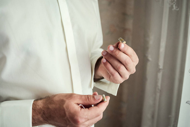 Businessman dresses white shirt, male hands closeup,groom getting ready in the morning before wedding ceremony - Foto, Imagem