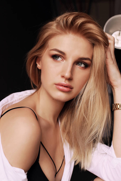 beautiful girl with blond hair in elegant clothes posing in stud - Fotó, kép