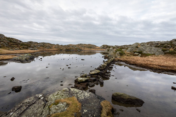 Pond by the trail, at the Rovaer archipelago, island in Haugesund, Norway. Stones making a path through the water. - Фото, изображение