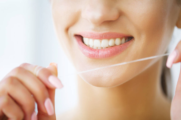 Teeth Care. Beautiful Smiling Woman Flossing Healthy White Teeth - Foto, Imagen