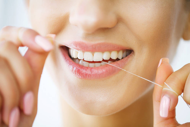 Cura dei denti. Bella donna sorridente filo interdentale denti bianchi sani
 - Foto, immagini