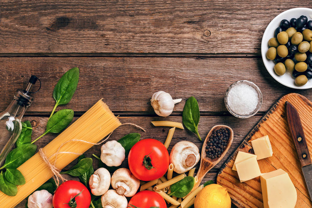 De achtergrond van de Italiaanse keuken met pasta, kruiden en groenten. Bovenaanzicht, kopie ruimte. - Foto, afbeelding